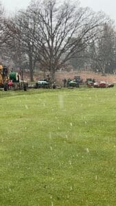 A field with several tractors parked in it.