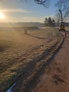 A tractor is driving down the road in the sun.