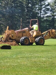 A man on a tractor is digging the ground.